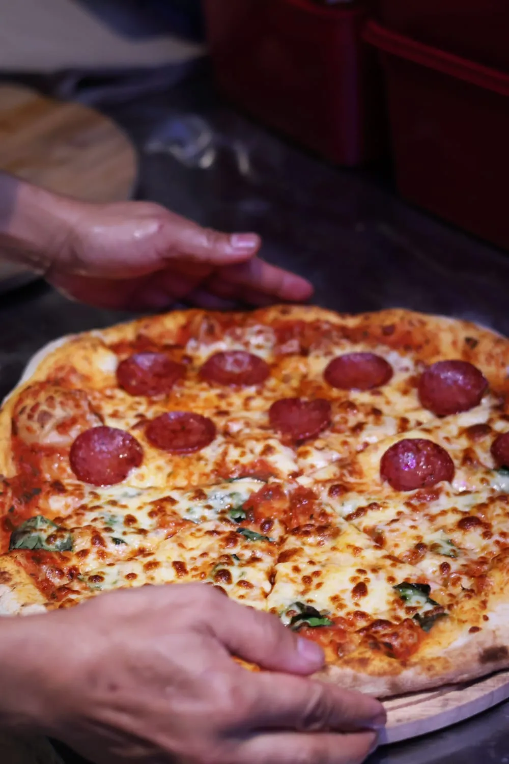 A whole NYPD pizza split in half — pepperoni on one side, classic cheese on the other.